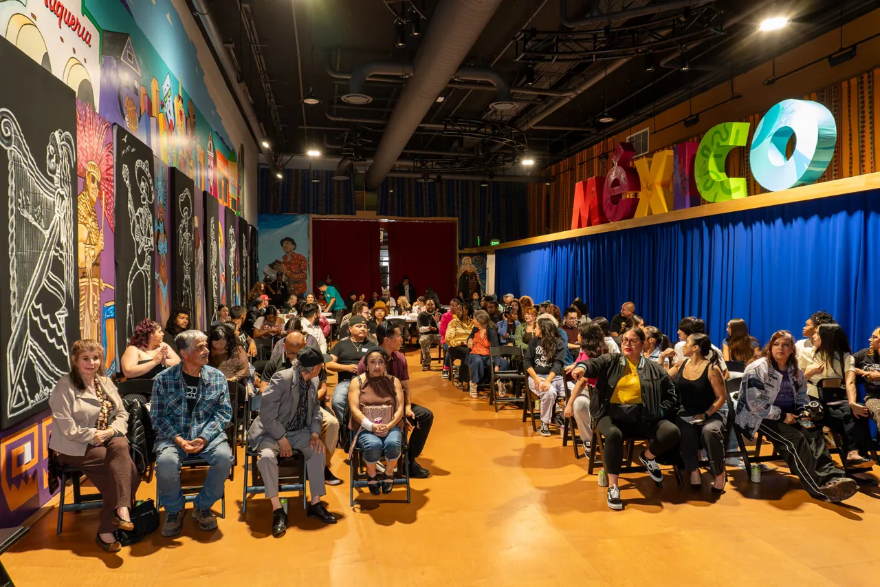 A wide view down the screening room shows guests seated on both sides of an open aisle.