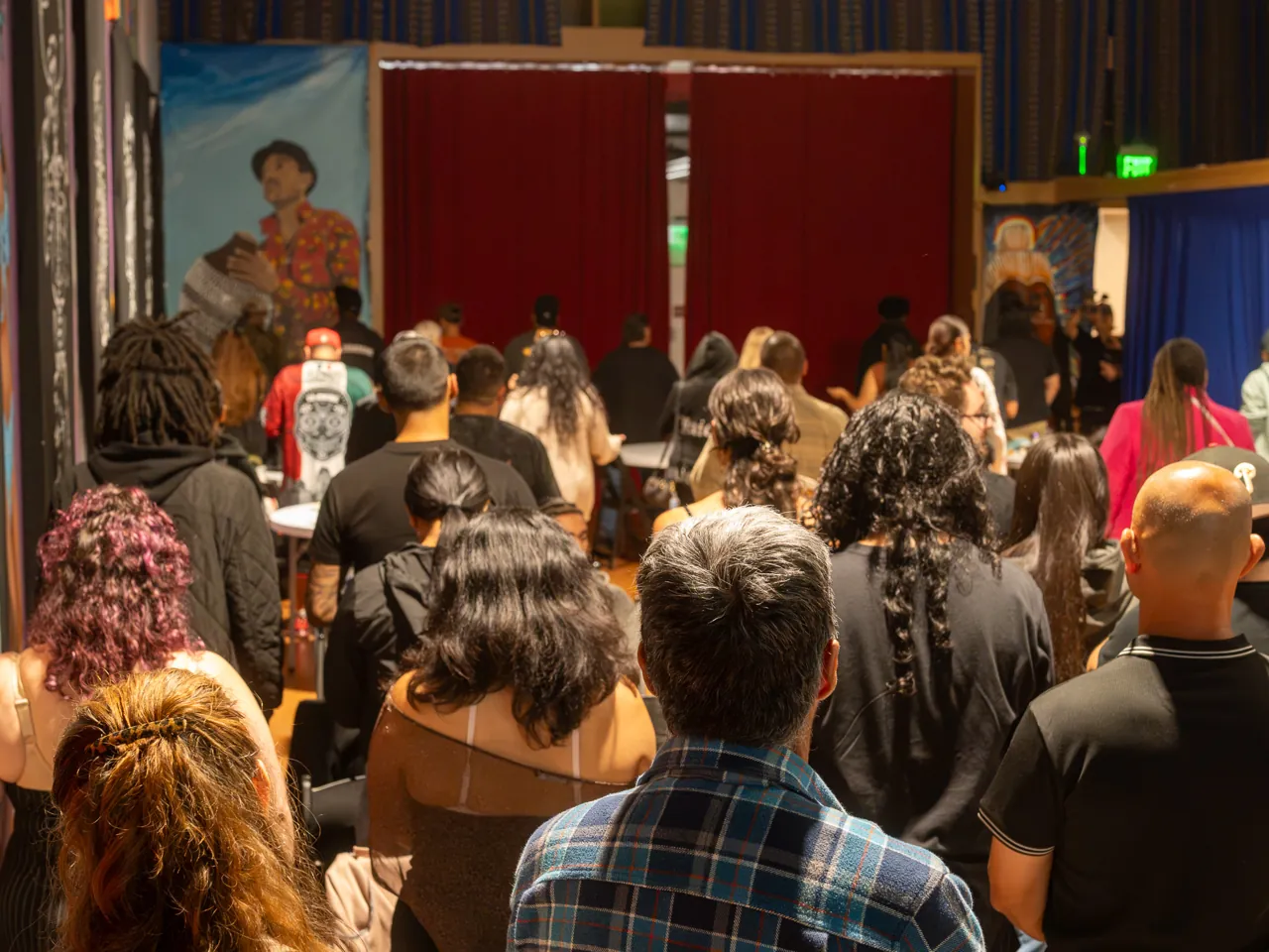 Guests stand together between rows of chairs during the community gathering.