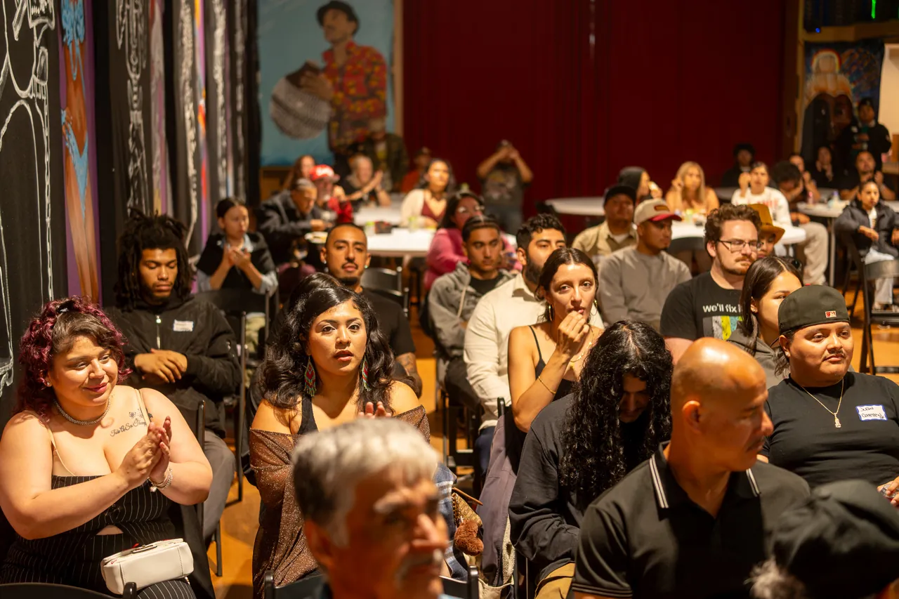 Audience members look toward the front of the screening room.