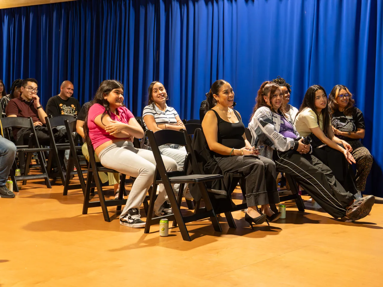 Guests seated against the blue curtain listen during the discussion.
