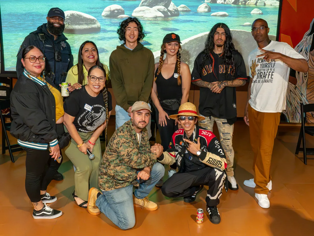 A group poses in front of the projection screen, with several guests crouching in the front row.