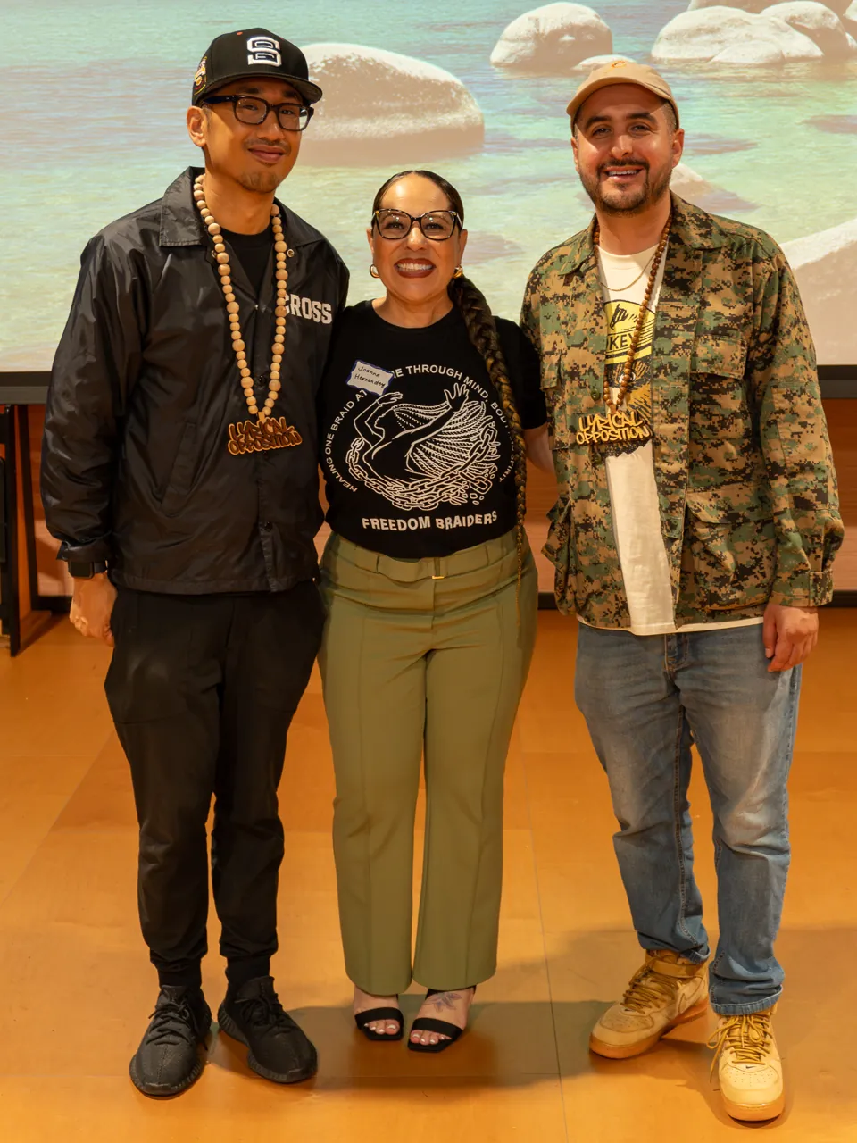 Three guests stand together for a portrait in the screening room.