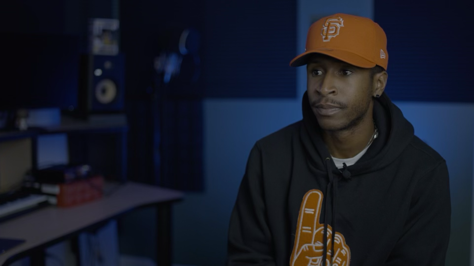 Interview subject wearing an orange San Francisco cap.