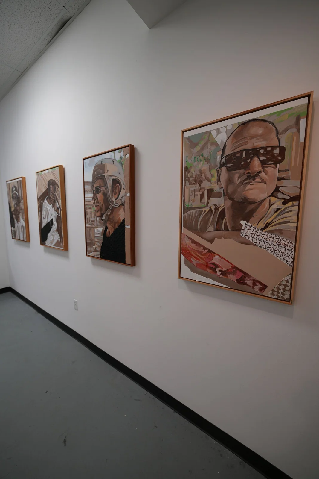Framed portraits displayed along a gallery wall.