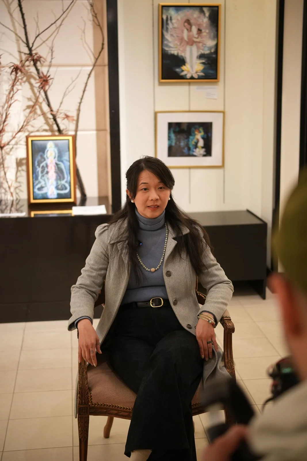 A participant sits for a recorded conversation in the gallery.
