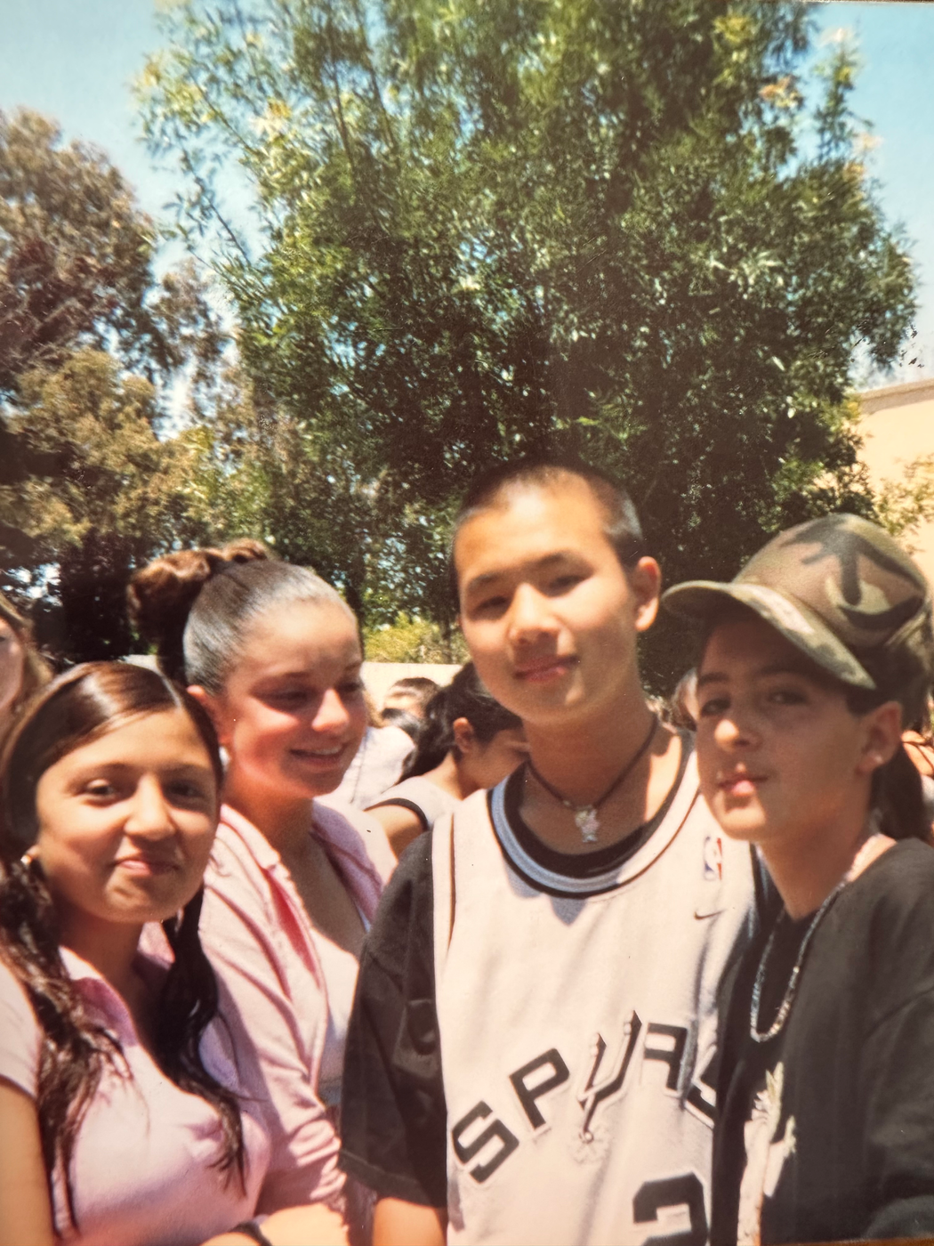 A group of cast and crew posing together outdoors on a sunny day.