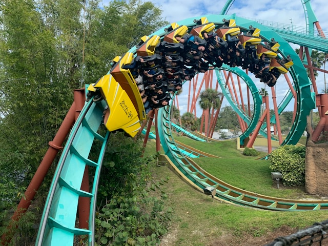 A yellow roller coaster going full throttle, almost upside down.