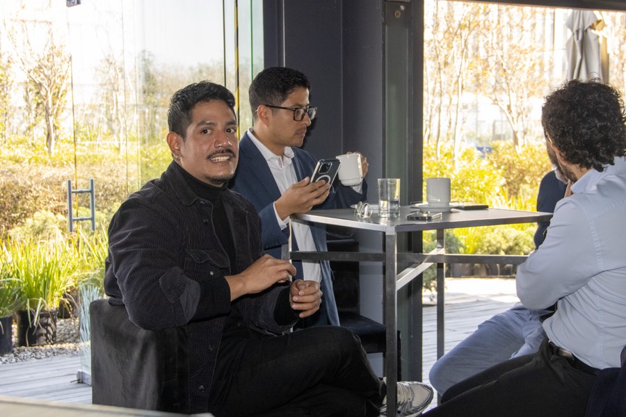 Asistentes conversando con un café junto al ventanal