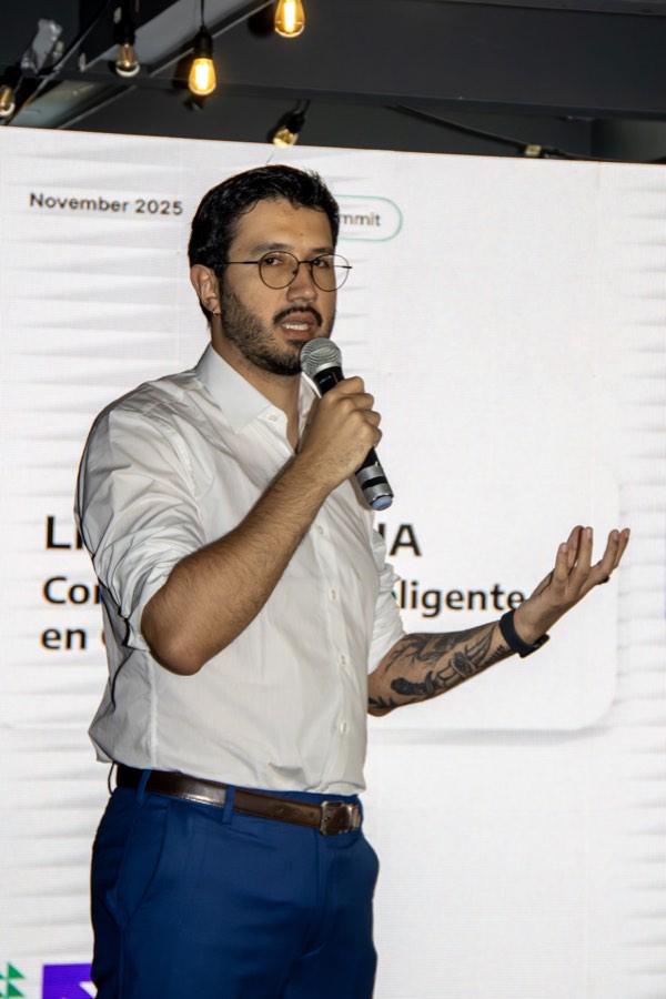 Ponente presentando con micrófono frente a la pantalla