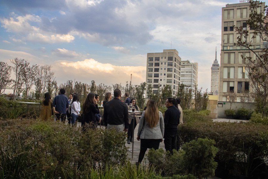 La terraza al atardecer, con los asistentes y el skyline de la ciudad