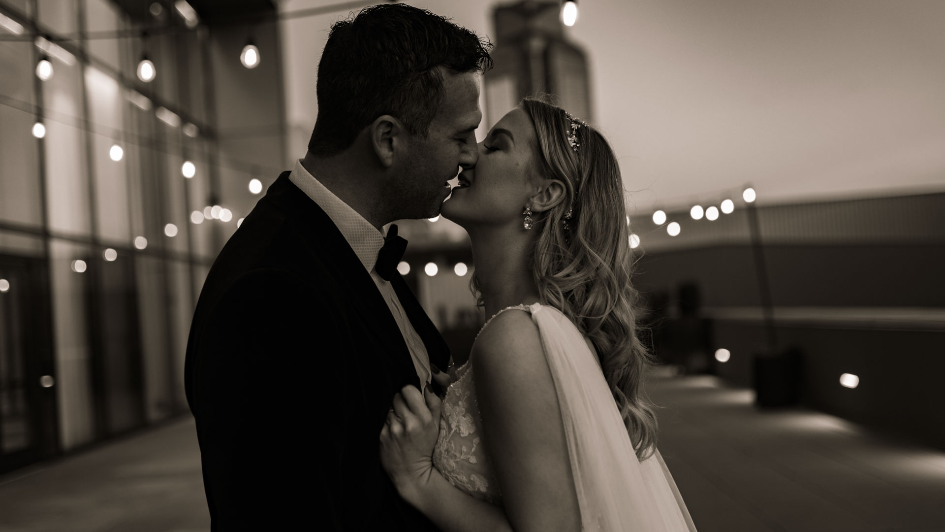 bride and groom about to kiss on a rooftop in the city