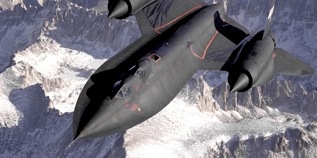A black aircraft flying over snowy landscapes.