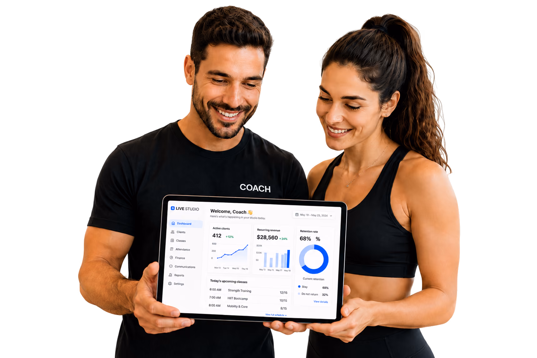 Male and female coaches smiling and holding a tablet displaying a fitness studio dashboard with stats and schedule.