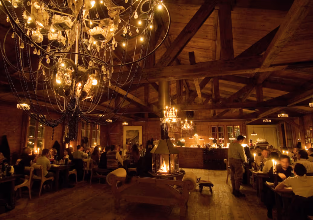 Cozy chalet-style interior at Fribourger Fonduestübli with fondue pots on the table.