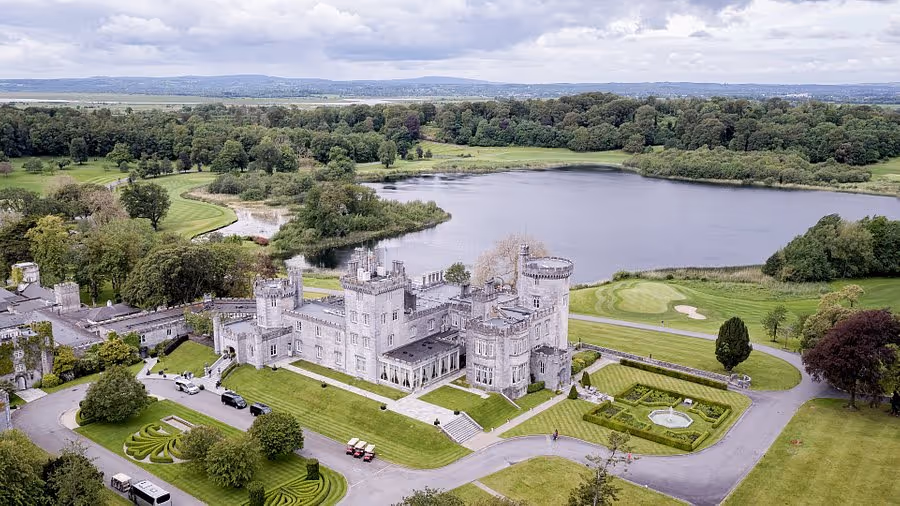Exterior of Dromoland Castle hotel reflected in the lake, County Clare, Ireland