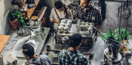 An image of a coffee shop with customers and baristas