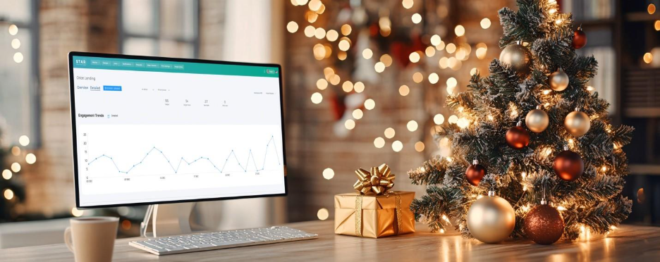 A computer on a desk with a small present and a small treeAI-generated content may be incorrect.