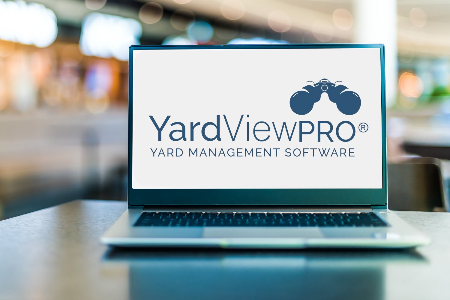 A computer laptop sitting on a table with the YardView Yard Management Software System logo on the screen