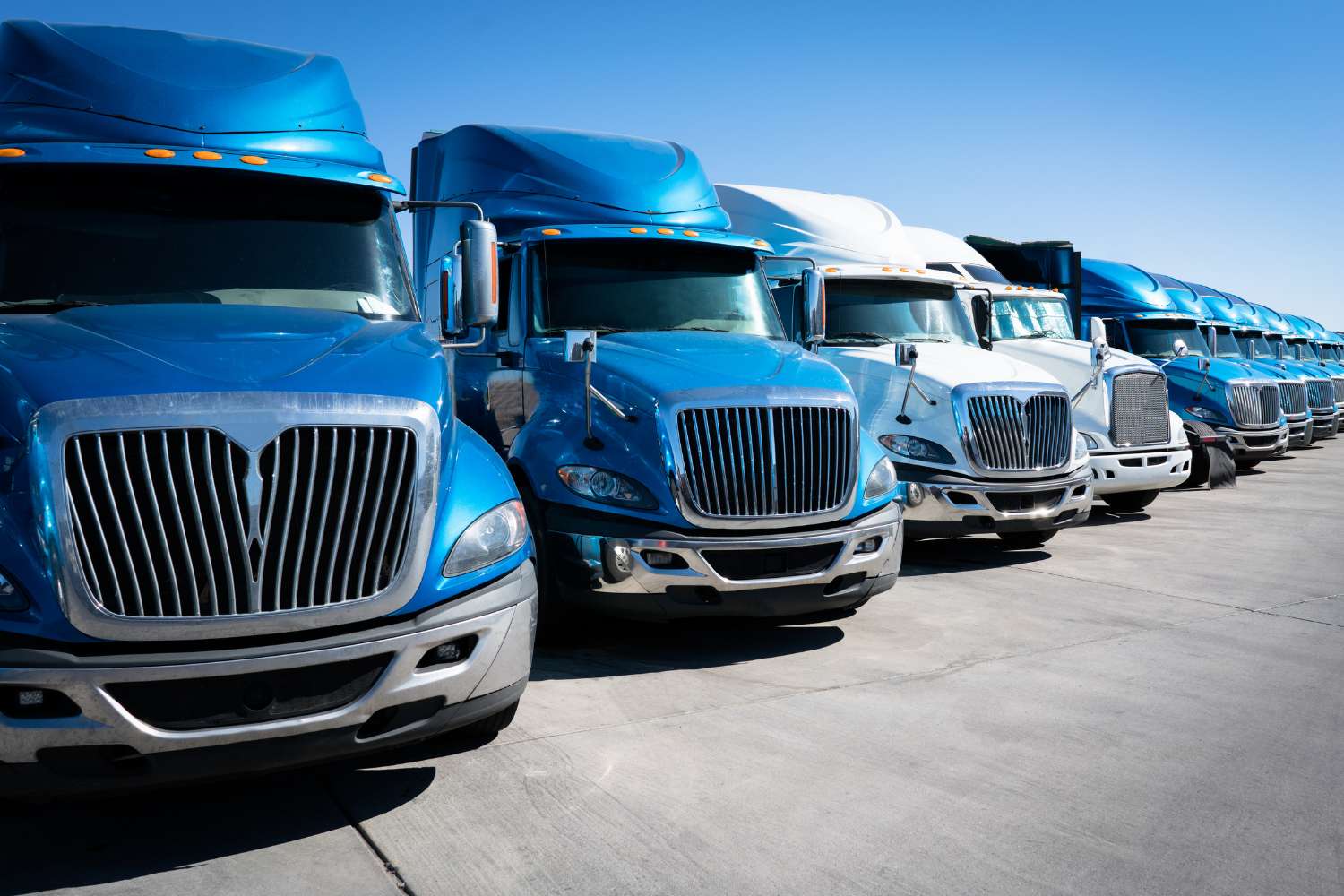 Rows of a fleet of blue and white semi-trucks offered by a 3PL vendor