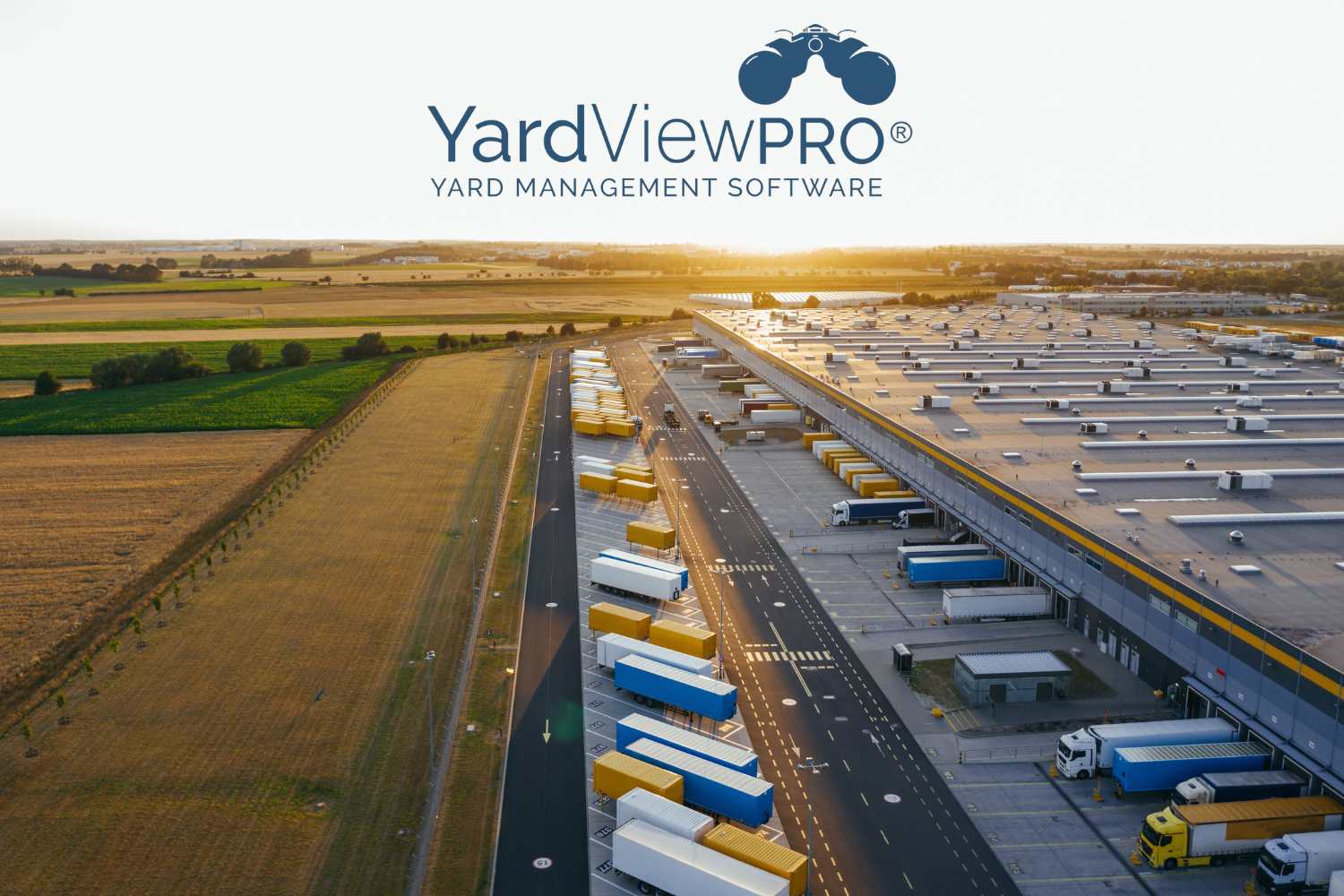 Aerial view of an efficient busy operations yard outside of a distribution center with the YardView logo in the sky