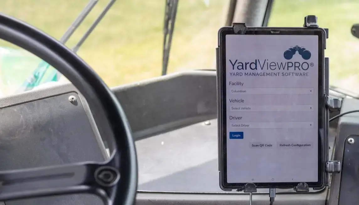 An in-cab tablet mounted in a truck next to a steering wheel and displaying the YardView YMS software.