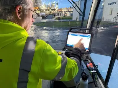 A yard driver touching an in-cab tablet.