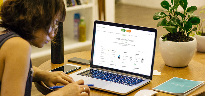 Young Woman Looking at GreenCars website and chargers