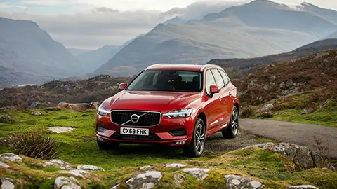 Un Volvo rojo en la cima de una montaña