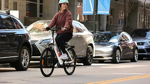 A women riding e-bike through the city