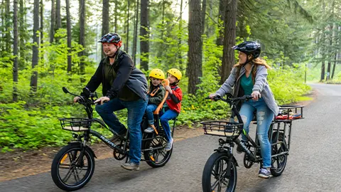 A family riding their e-bikes through a forest