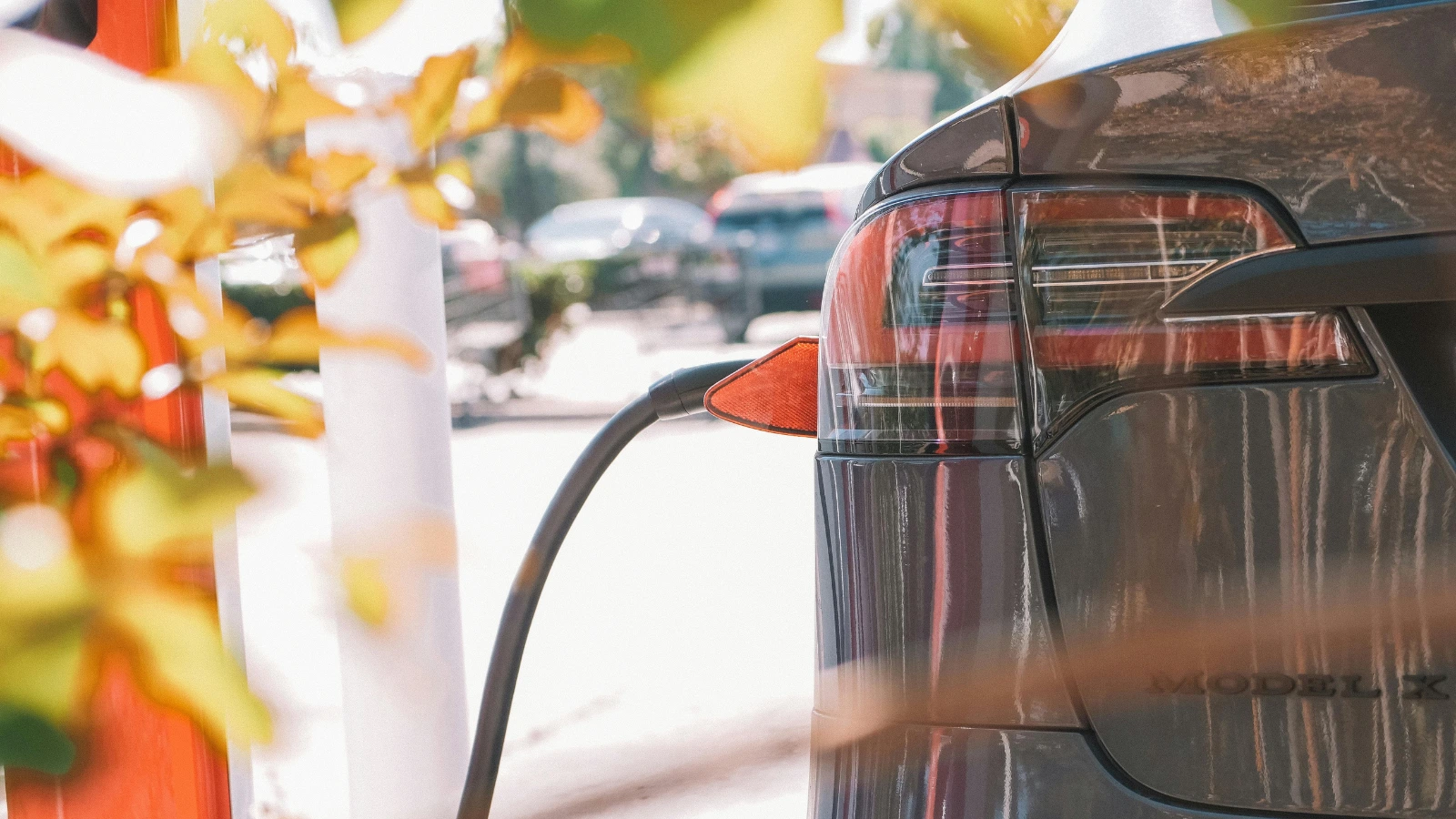 vehículo eléctrico estacionado y enchufado a un cargador eléctrico público