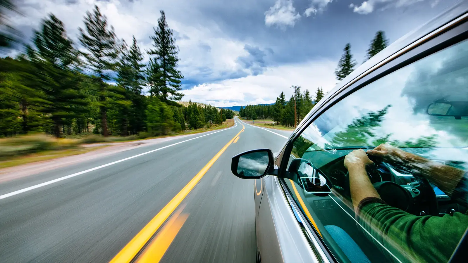 An electric vehicle driving down a mountain road