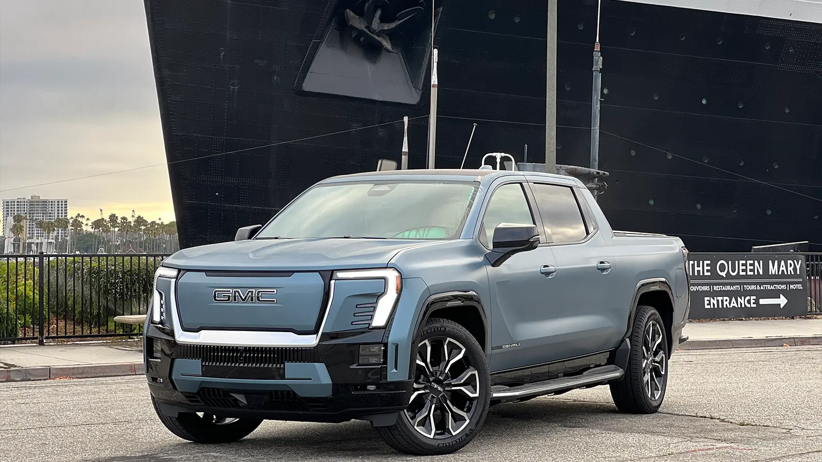 Un GMC Sierra EV Denali azul en la bahía junto al Queen Mary 