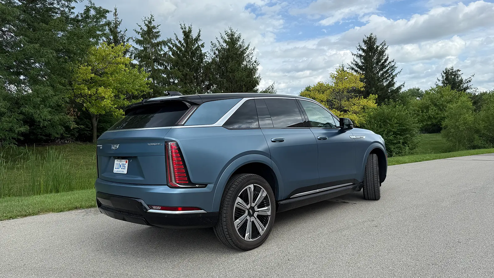 A light blue 2025 Cadillac Escalade IQ side view