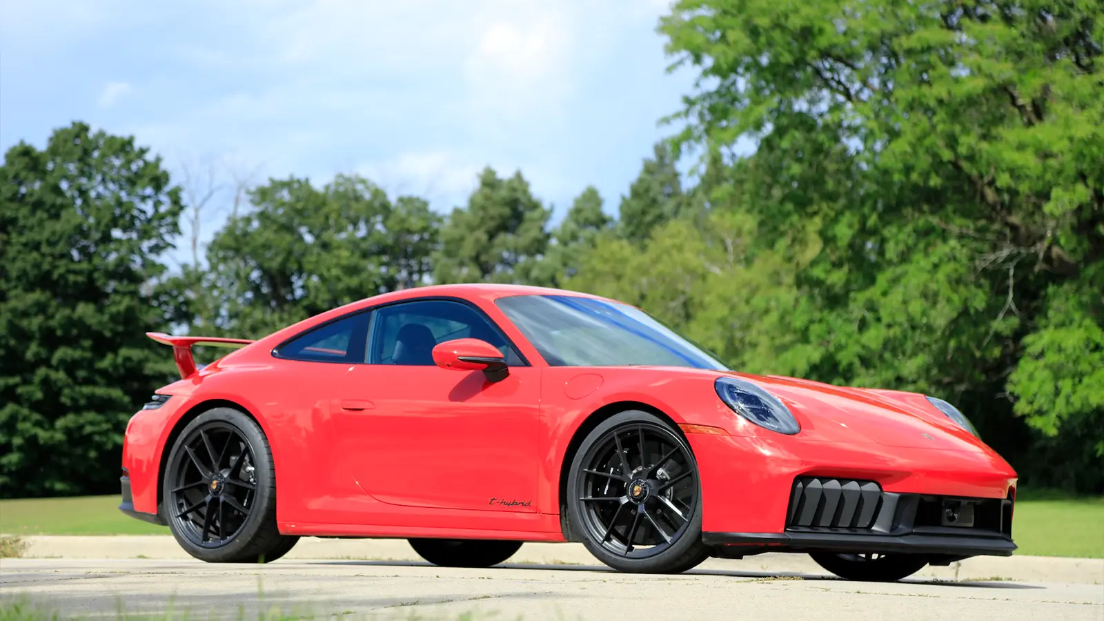 A red 2025 Porsche 911 Carrera GTS Hybrid side view