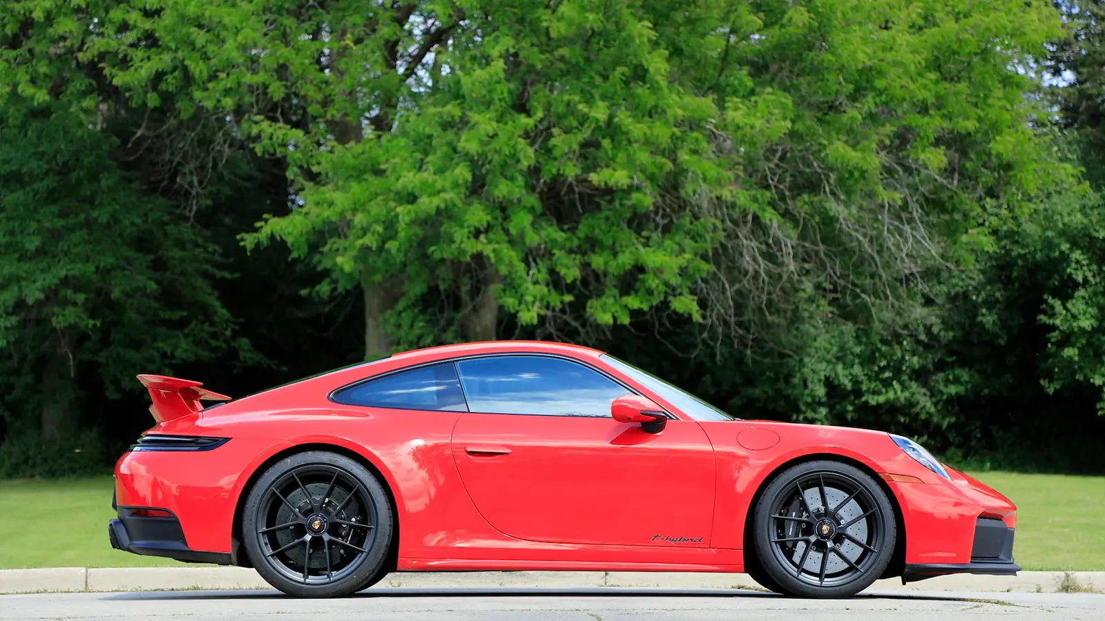 A red 2025 Porsche 911 Carrera GTS Hybrid side view