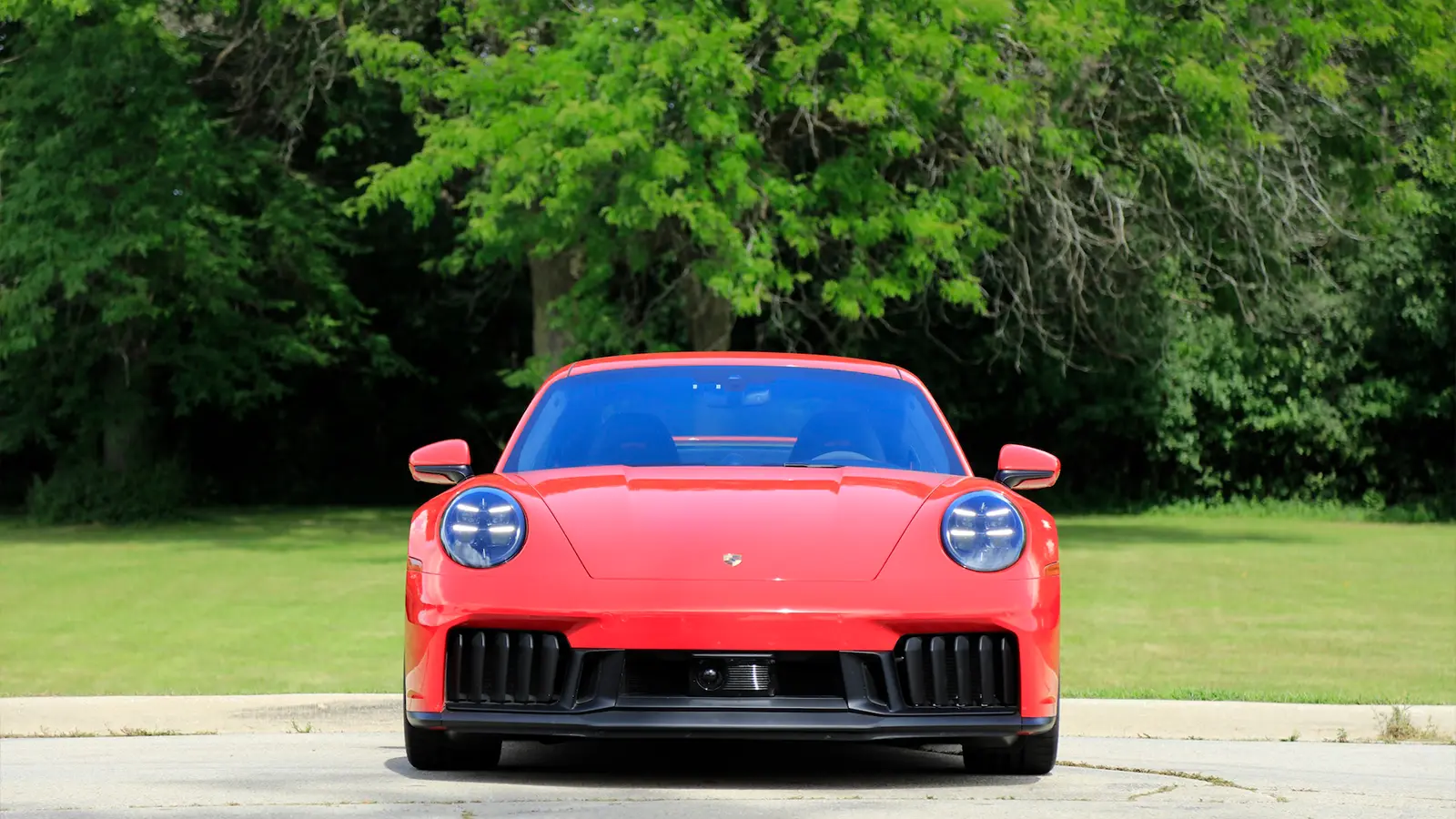 A red 2025 Porsche 911 Carrera GTS Hybrid front view