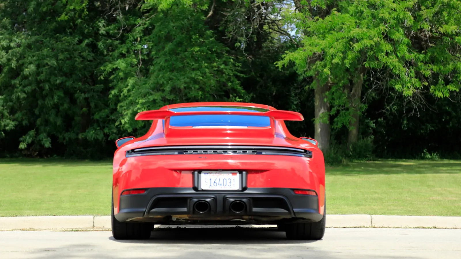 A red 2025 Porsche 911 Carrera GTS Hybrid rear view