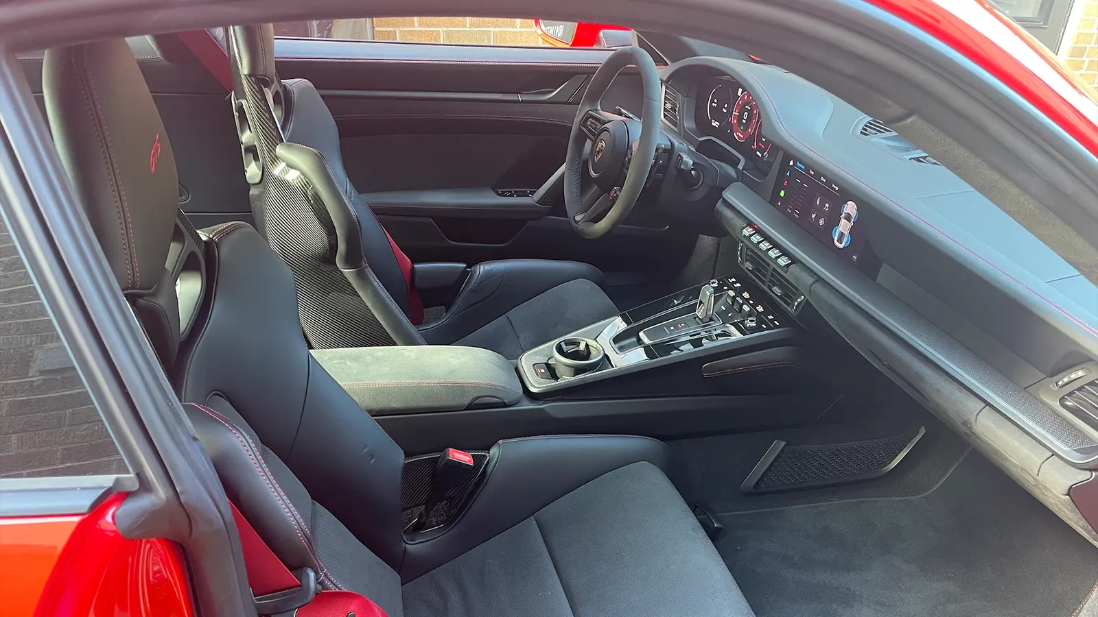 A red 2025 Porsche 911 Carrera GTS Hybrid side view