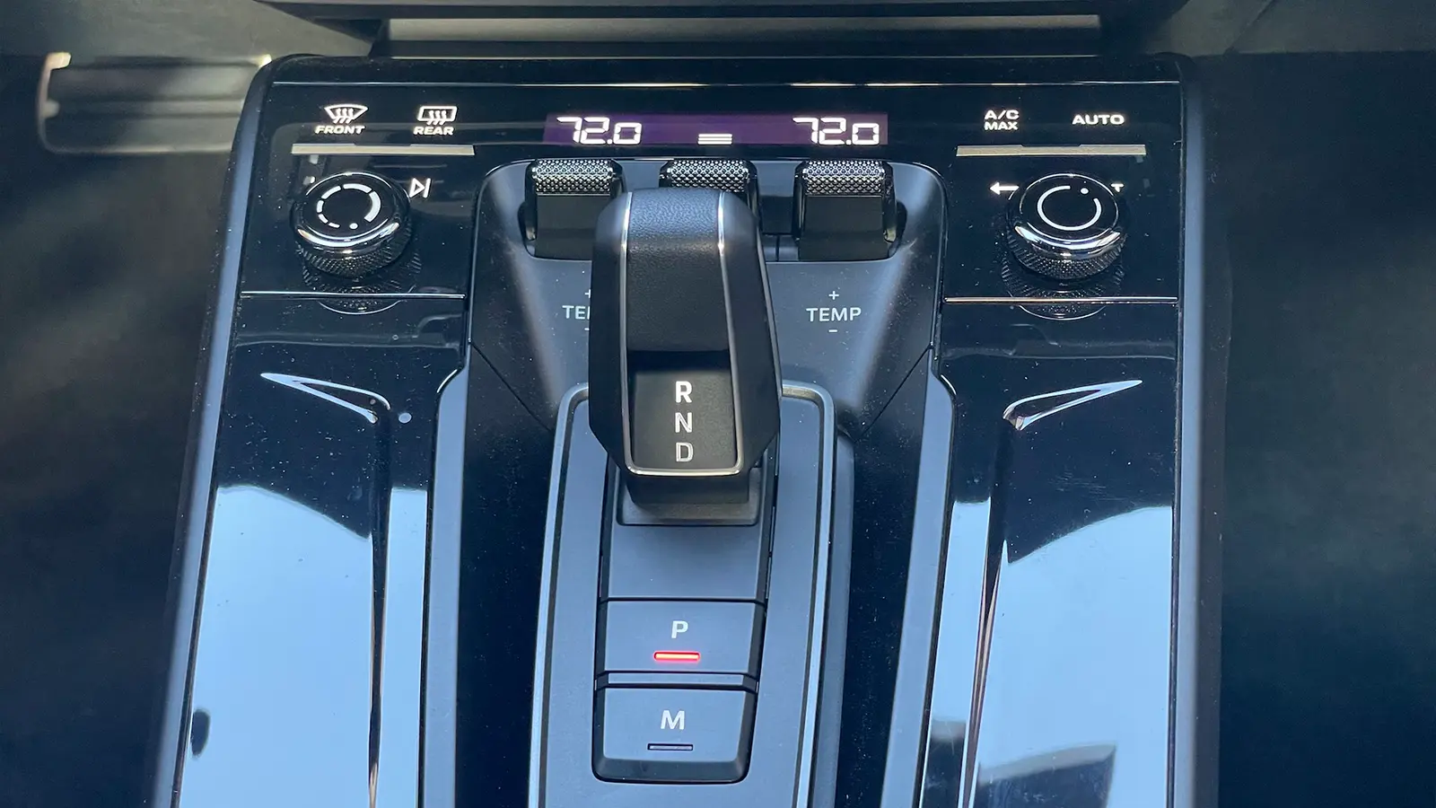 A red 2025 Porsche 911 Carrera GTS Hybrid console controls
