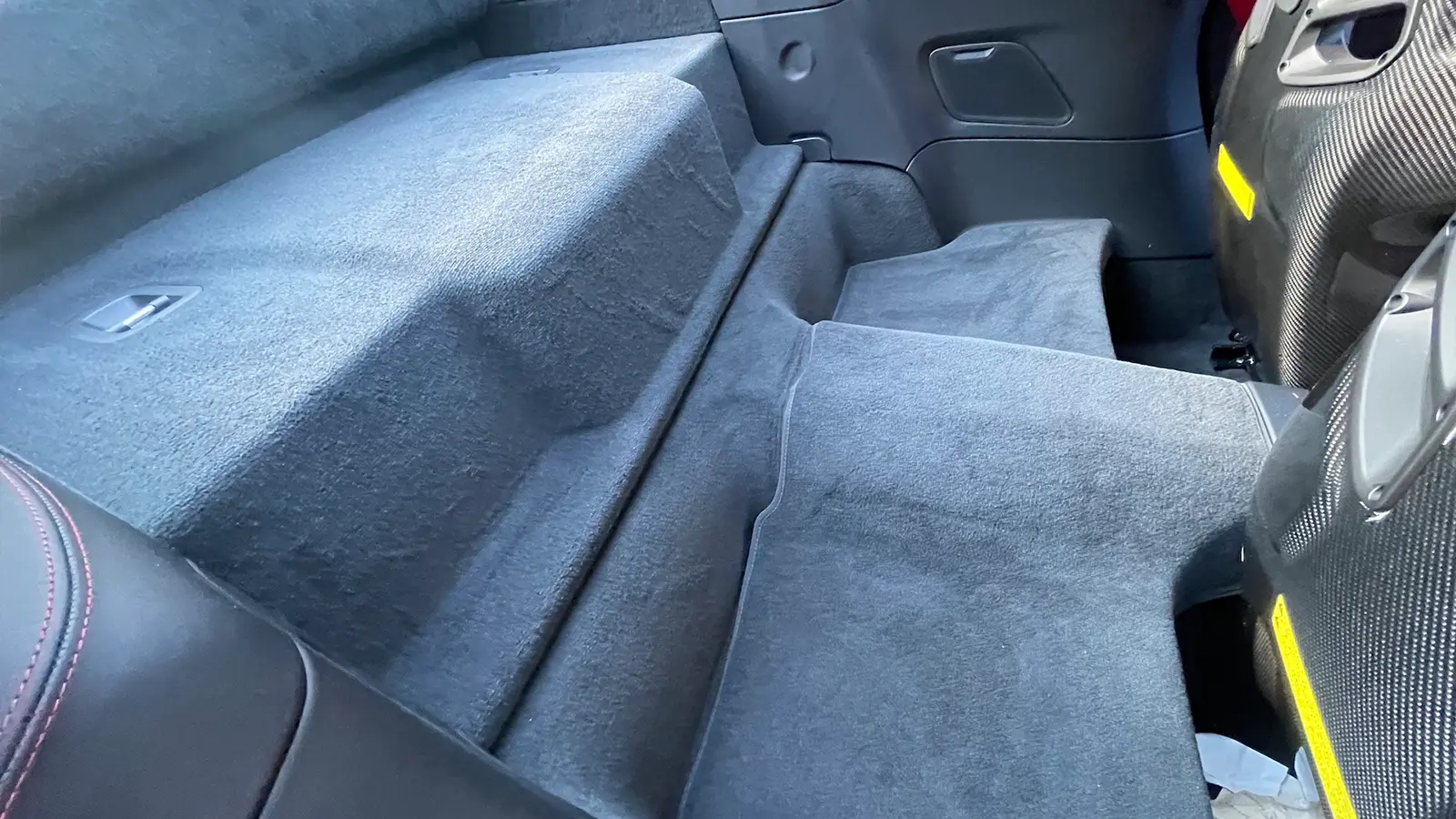A red 2025 Porsche 911 Carrera GTS Hybrid rear seat