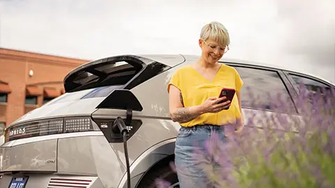 Persona parada al lado de un vehículo eléctrico 