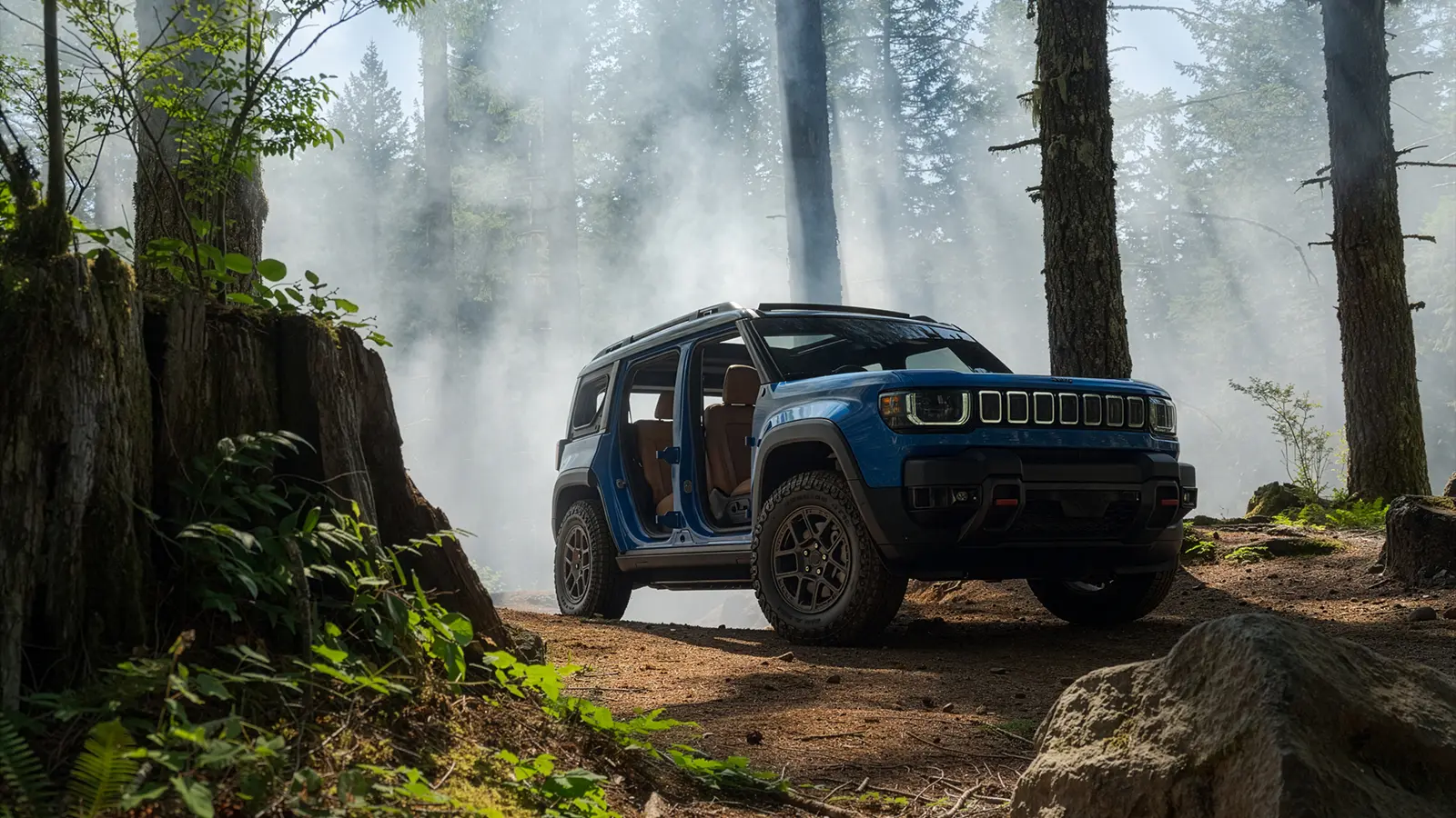 A blue 2026 Jeep Recon EV in a misty forest with the doors off