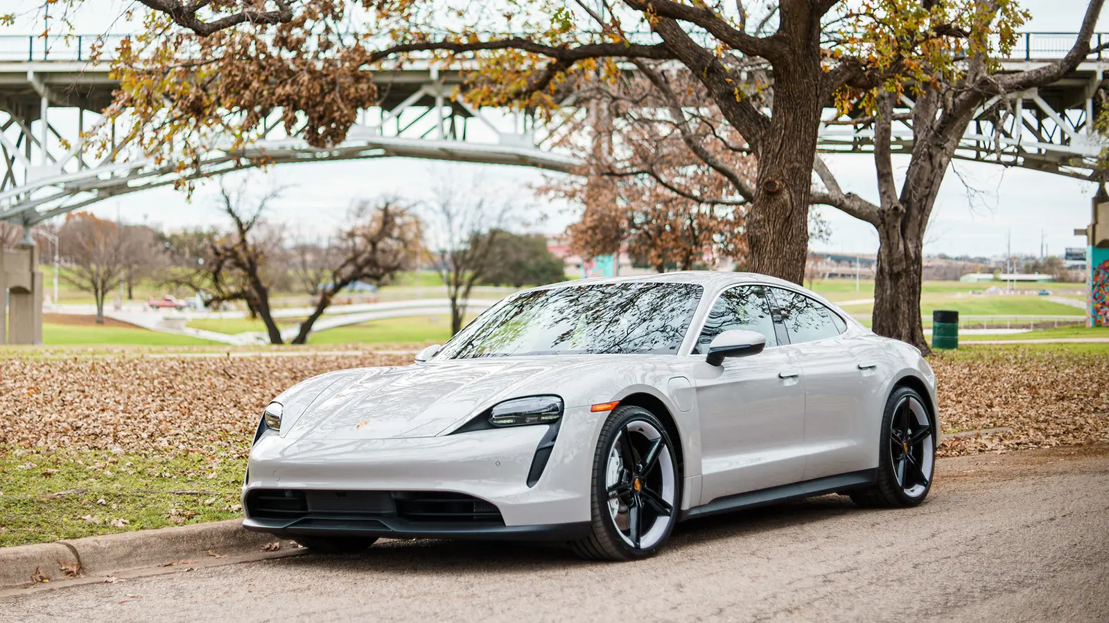 A white Porsche Taycan 4S in a park