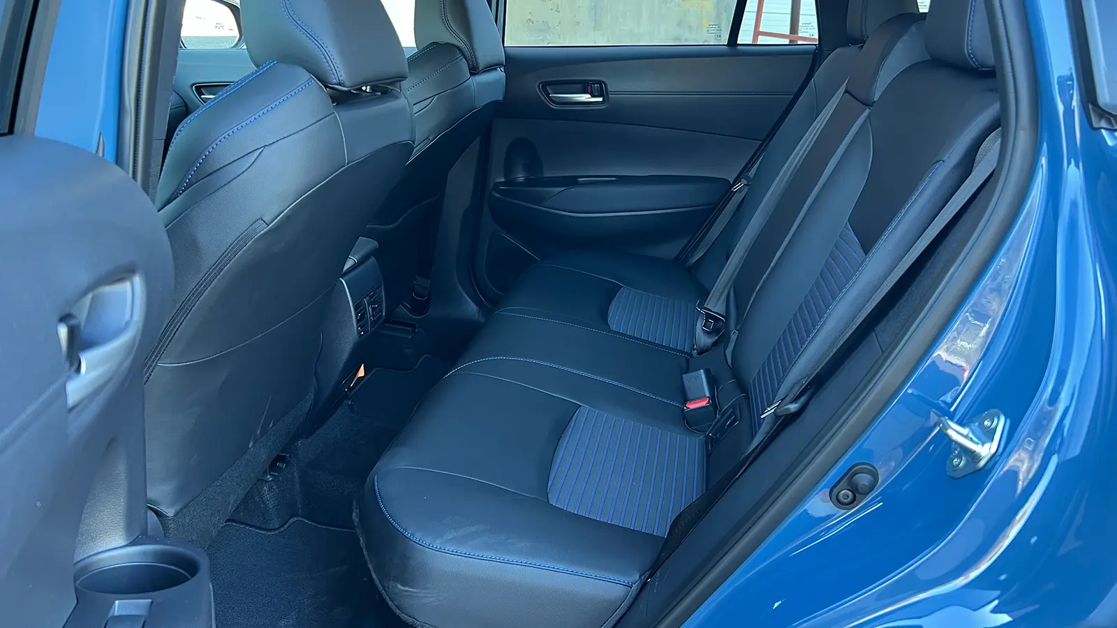 A blue 2026 Toyota Corolla Cross hybrid rear seat view