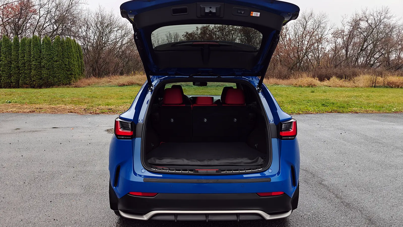 A blue 2026 Lexus NX 350h F Sport rear view cargo hatch open