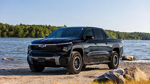 A 2026 black Chevrolet Silverado EV Trail Boss parked near the water