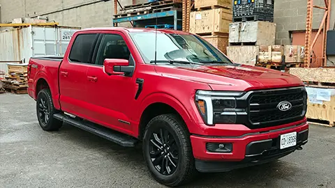 A red 2025 Ford F-150 Powerboost Lariat