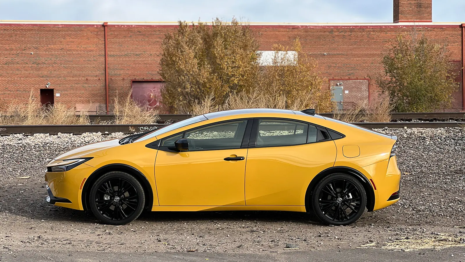 A yellow 2026 Toyota Prius XSE PHEV Nightshade side view