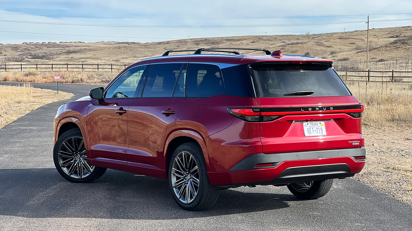A red 2026 Lexus TX 550h+ PHEV three quarter side view